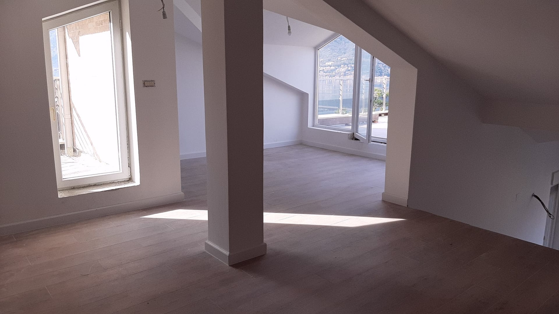 Helles Wohnzimmer im Dachgeschoss mit Panoramafenstern und Meerblick in Wohnung Nr. 159, Dobrota, Montenegro.