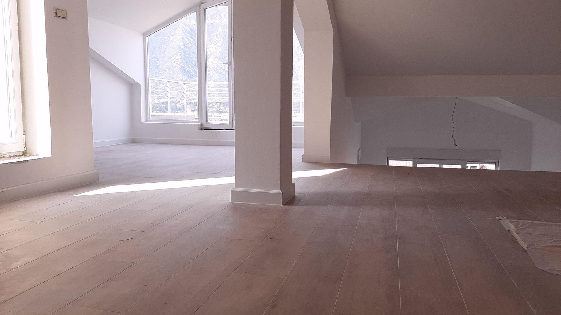 Helles Wohnzimmer im Dachgeschoss mit Blick auf die Berge, Wohnung in Dobrota, Montenegro: moderne Ausstattung und Panoramafenster.