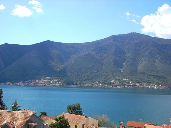 Panoramablick auf die Bucht von Kotor und die Berge aus einer Wohnung in Dobrota, Montenegro: Meer und Ziegeldächer der Häuser.