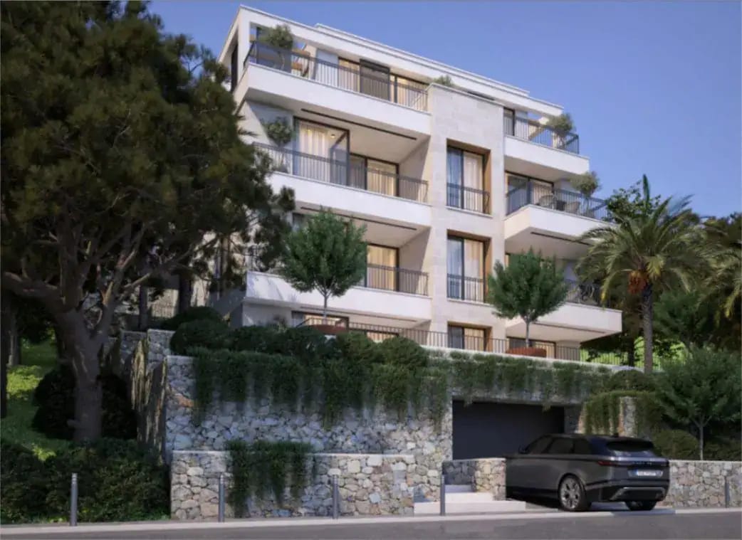 Complexe résidentiel moderne à Tivat, Monténégro : façade du bâtiment avec terrasses, parement en pierre et parking devant la maison.