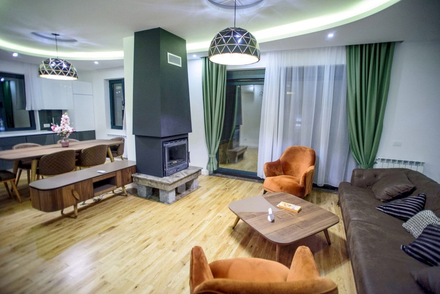 Dnevna soba sa kaminom i modernim nameštajem u vili na Luštici, Crna Gora: stilizovan enterijer sa parketnim podom.