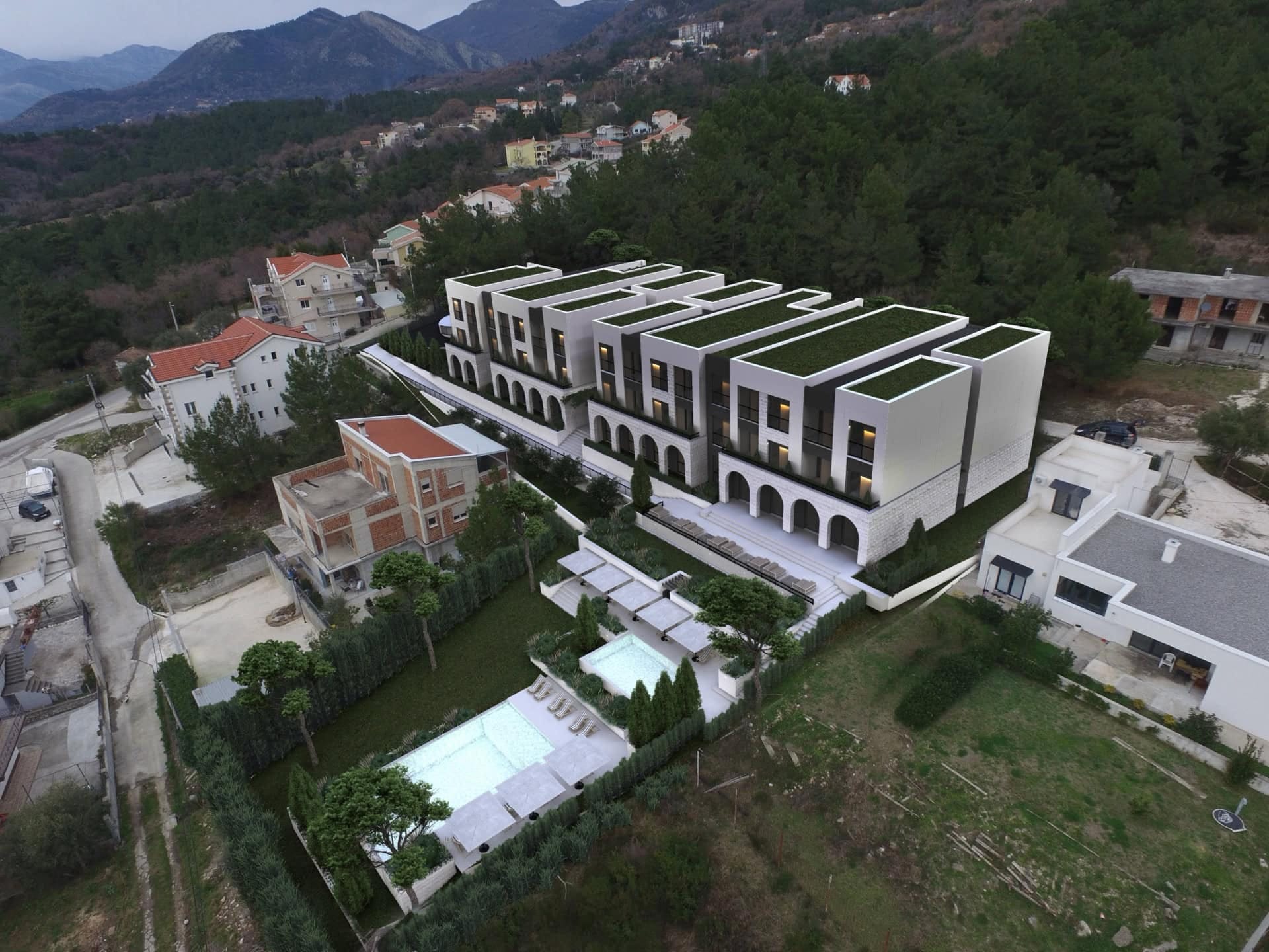 Savremeni stambeni kompleks sa bazenima u Kavaču, Crna Gora: pogled iz vazduha na arhitekturu i pejzaž objekta.