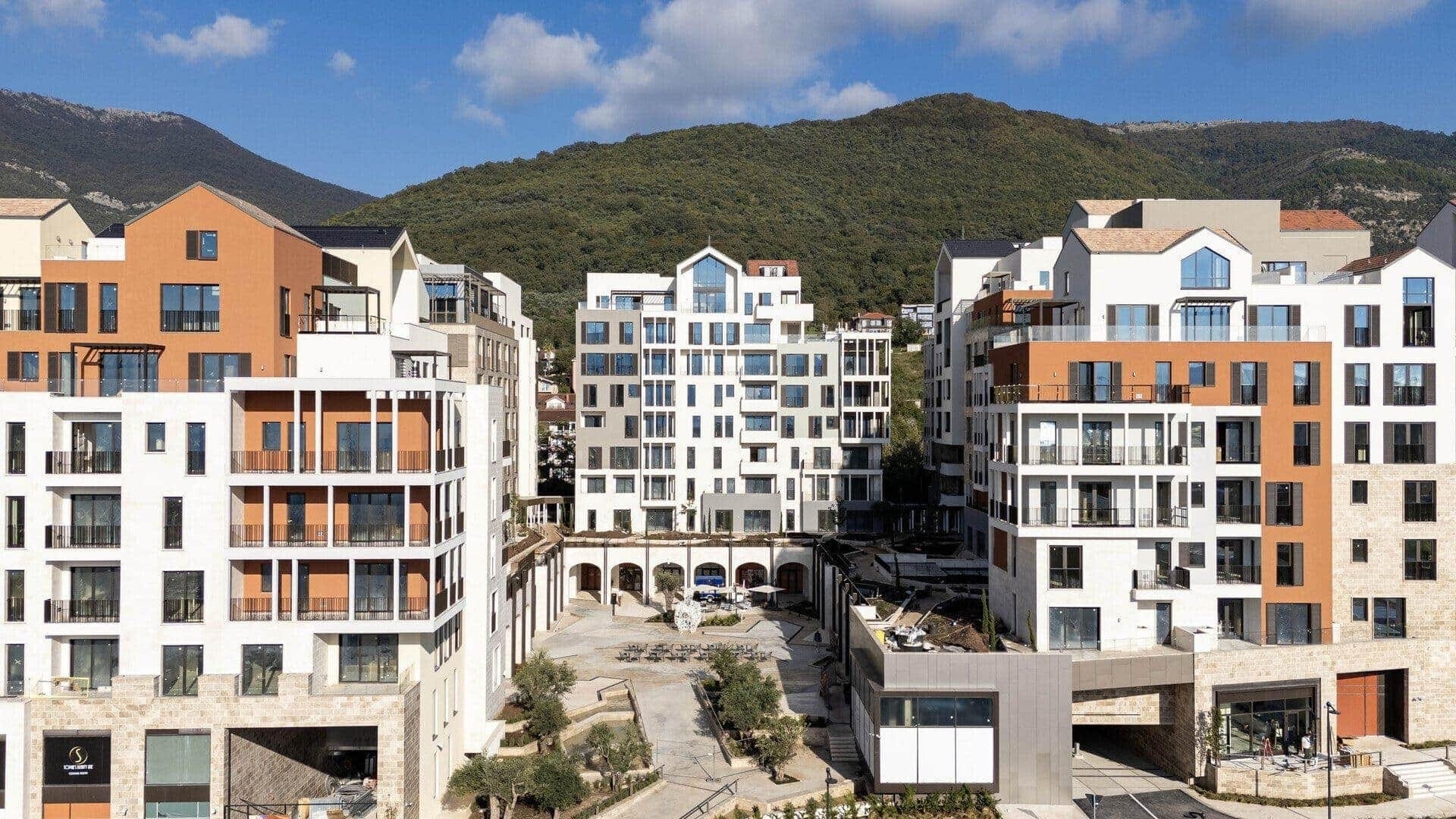 Savremeni stambeni kompleks u Porto Montenegru, Tivat, Crna Gora: pogled na fasade zgrada i uređeno dvorište.