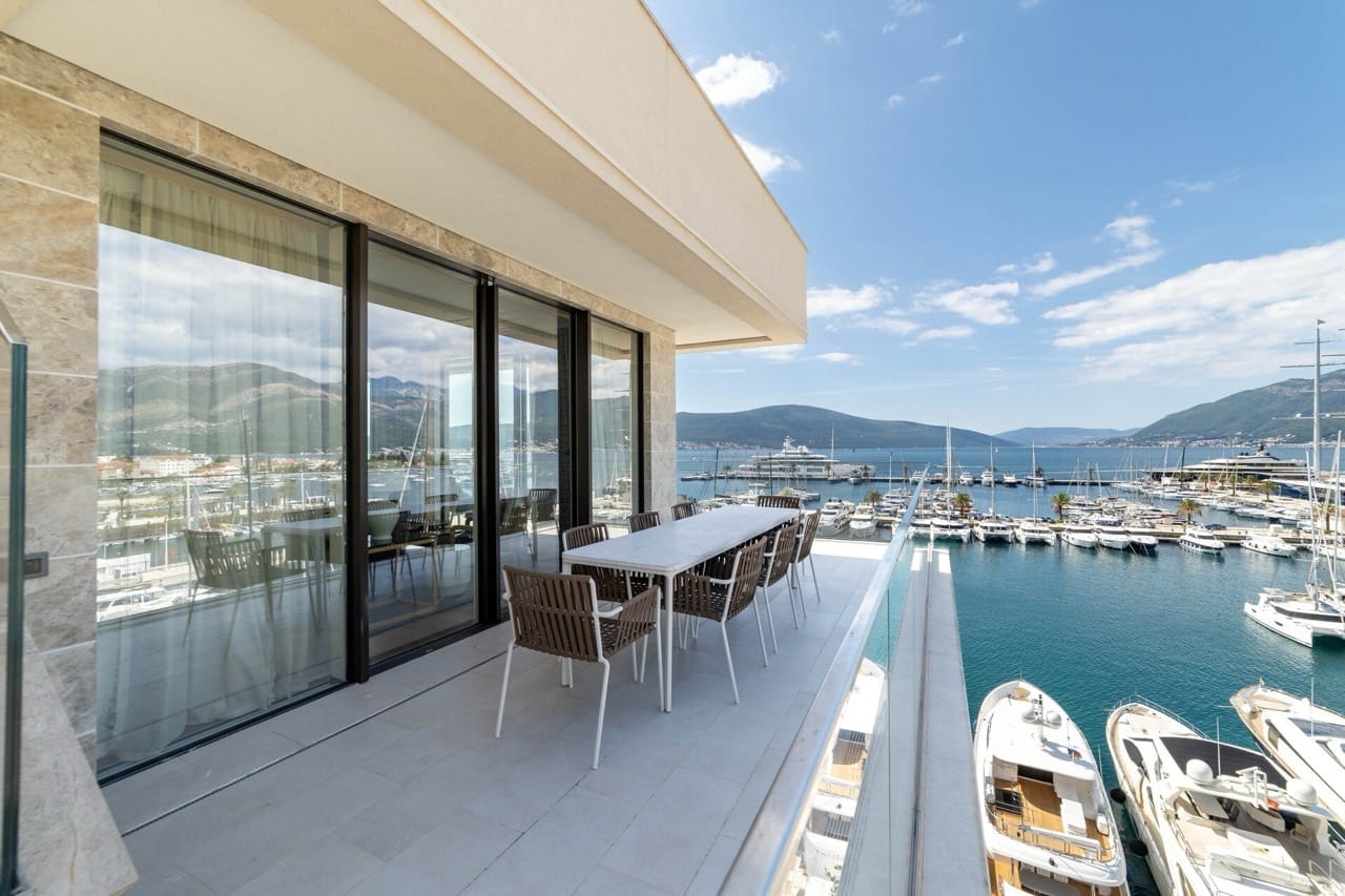 Taras z jadalnią i widokiem na marinę Porto Montenegro, Tivat, Czarnogóra: nowoczesne meble i panoramiczne okna.
