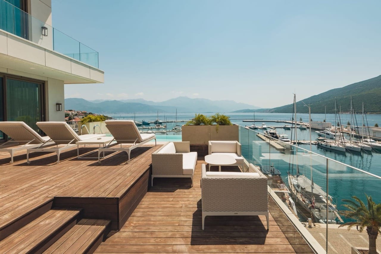 Terrace with loungers and a view of Portonovi Marina, Kumbor, Montenegro: wooden decking and premium outdoor furniture.