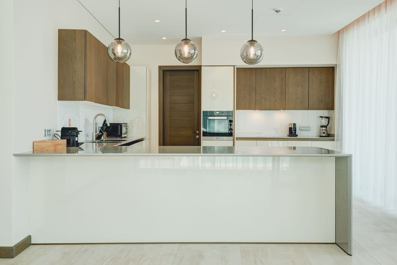 Modern kitchen with island in an apartment in Portonovi, Kumbor, Montenegro: wood-front cabinets and built-in appliances.
