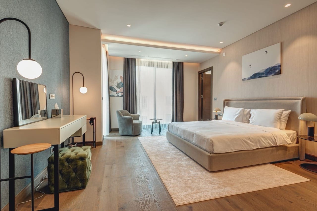 Modern bedroom in an apartment in Portonovi, Kumbor, Montenegro: double bed, vanity table, and armchair.