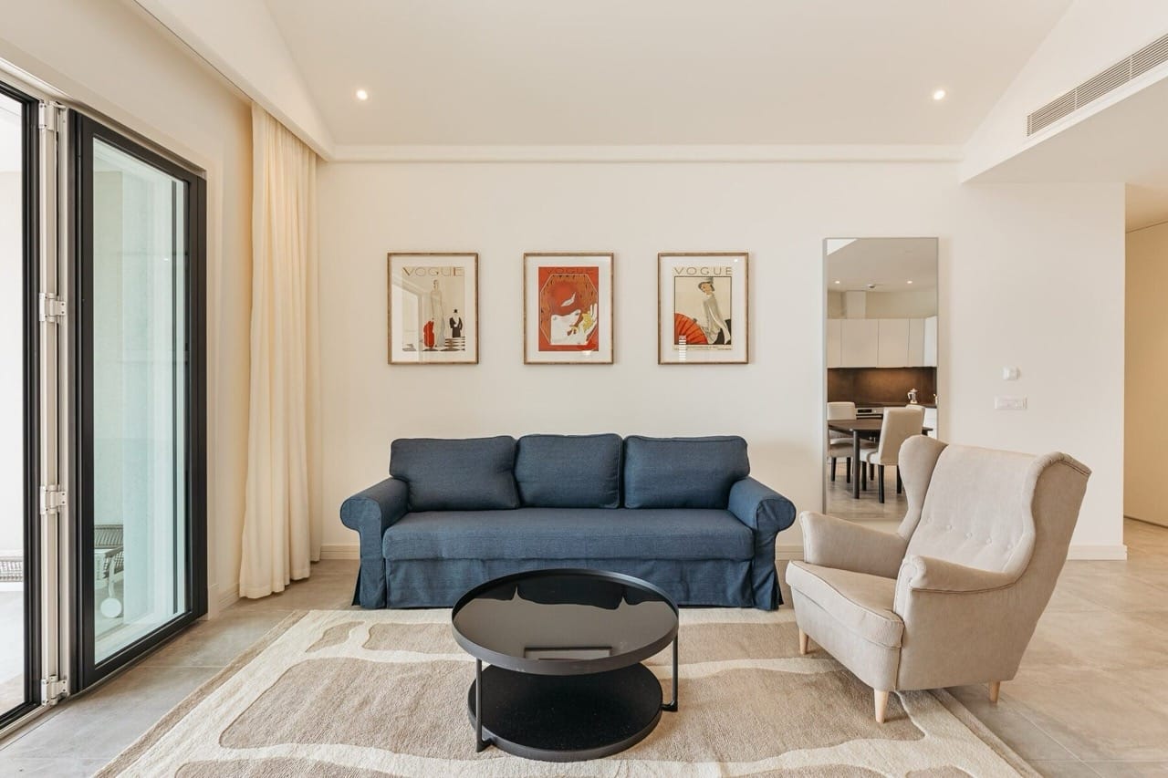 Bright living room in Lustica Bay apartments, Radovici, Montenegro: blue sofa, armchair, and coffee table.