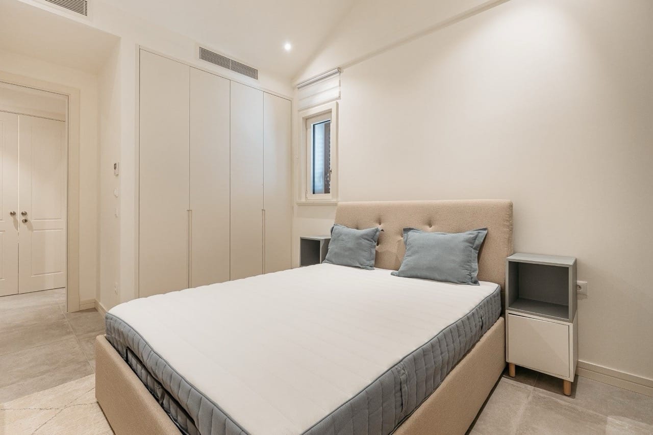 Bright bedroom with a double bed and built-in wardrobe in Lustica Bay apartments, Radovići, Montenegro.