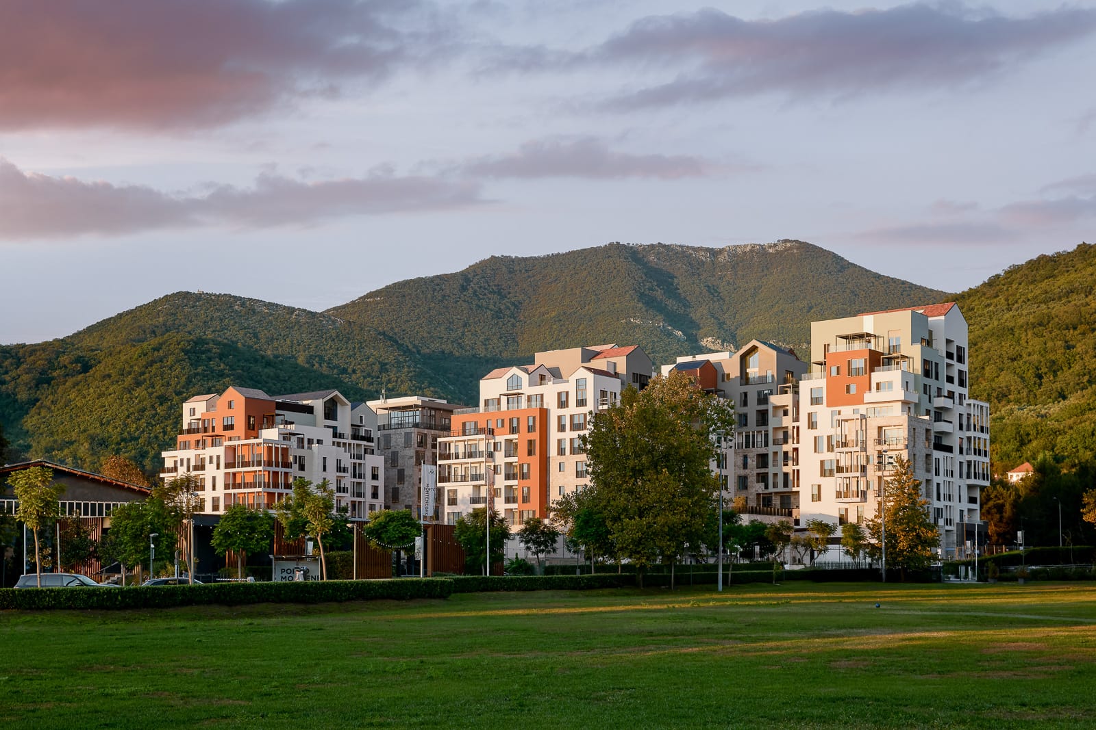 Savremeni stambeni kompleks u Porto Montenegru, Tivat, Crna Gora: pogled na luksuzne kuće u pozadini planinskog pejzaža.