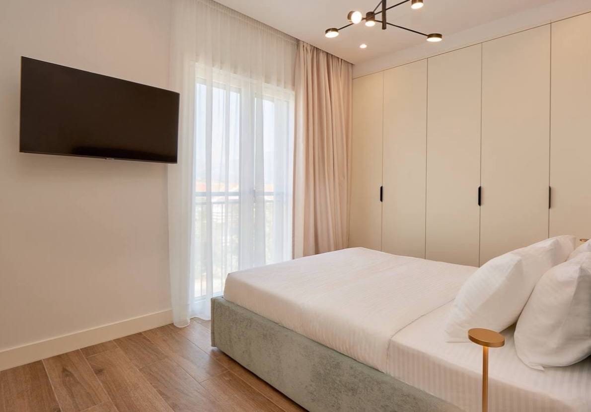 Savremena spavaća soba sa bračnim krevetom i ugradnim ormarom u apartmanima Luštica Bay, Crna Gora.