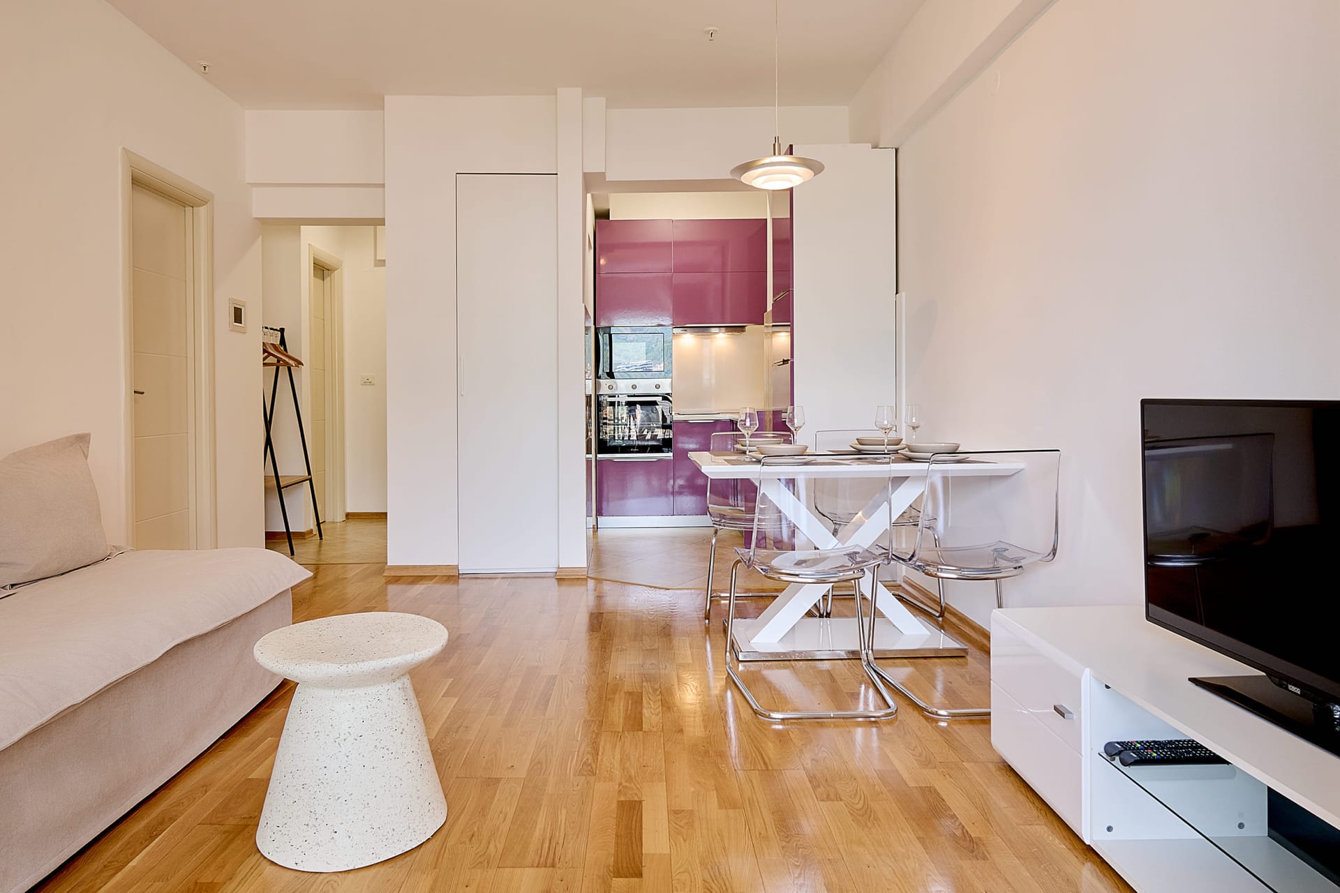 Wohnzimmer mit Küche in einer Apartmentanlage in Bečići, Montenegro: moderne Möbel, Essbereich und Parkettboden.