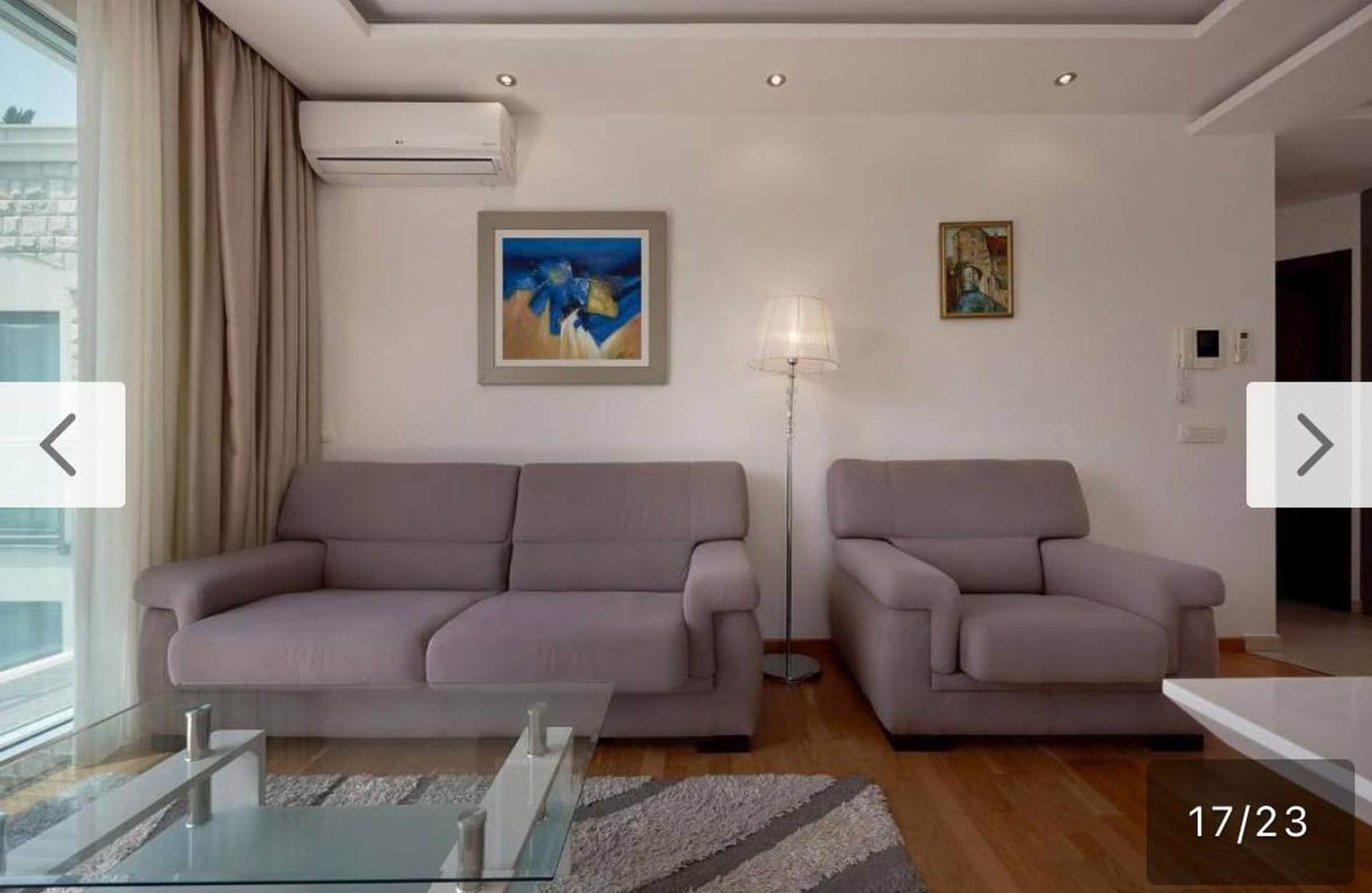 Moderna dnevna soba u apartmanima u Bečićima, Crna Gora: tapacirani nameštaj, parket, klima uređaj i panoramski prozor.
