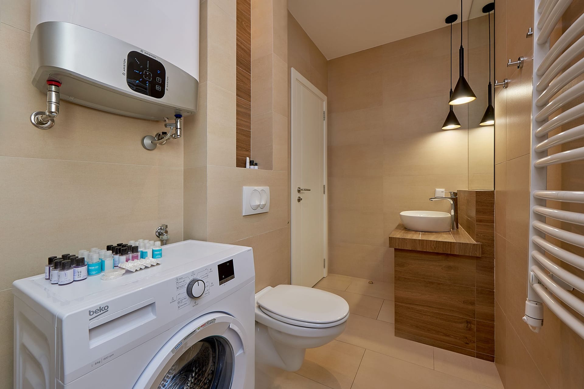 Moderna kupatilo sa tušem i mašinom za veš u apartmanima u Bečićima, Crna Gora.