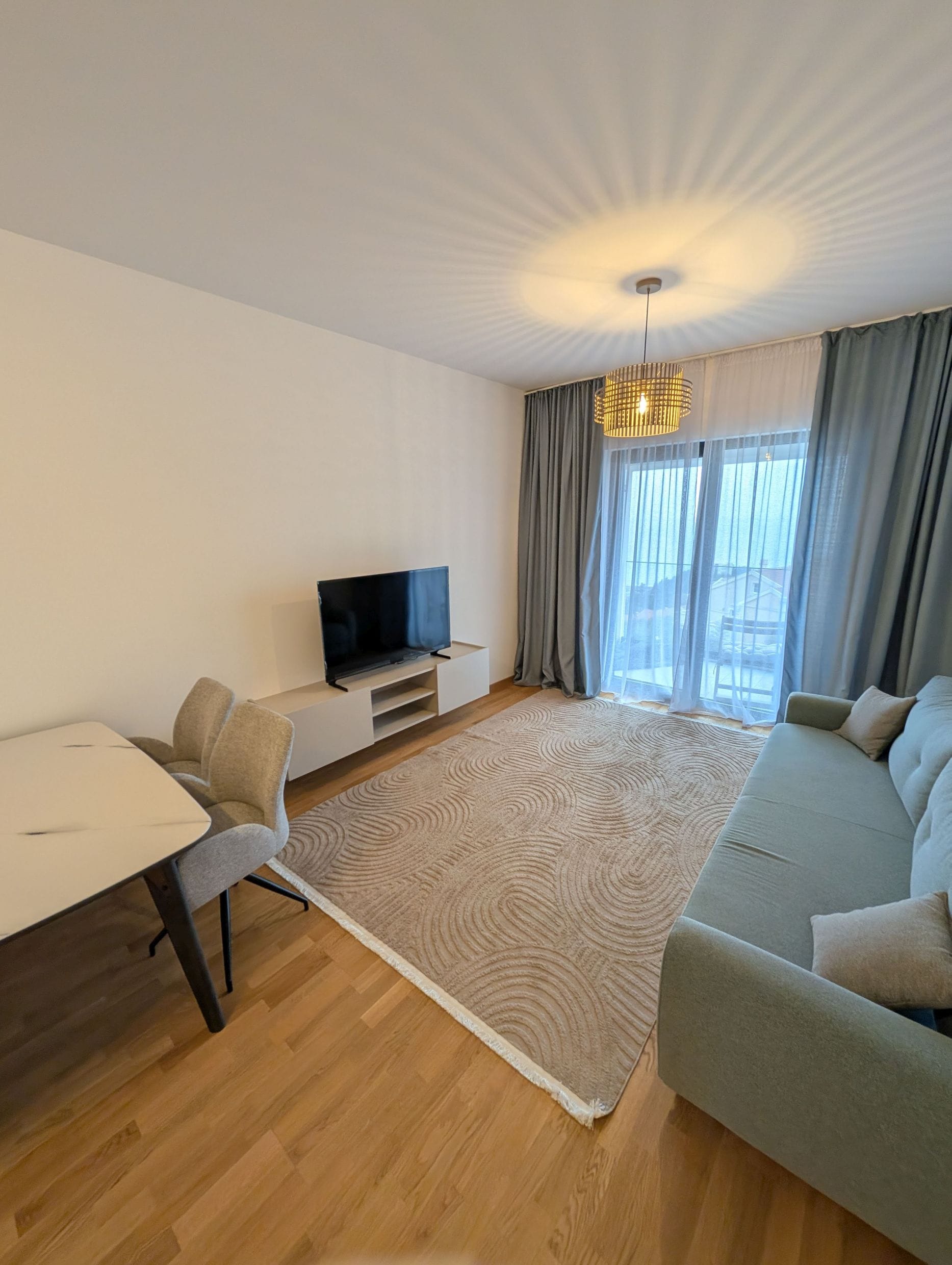 Moderna dnevna soba u apartmanima, Bečići, Crna Gora: sofa, trpezarijski deo, TV i panoramski prozor sa pogledom.