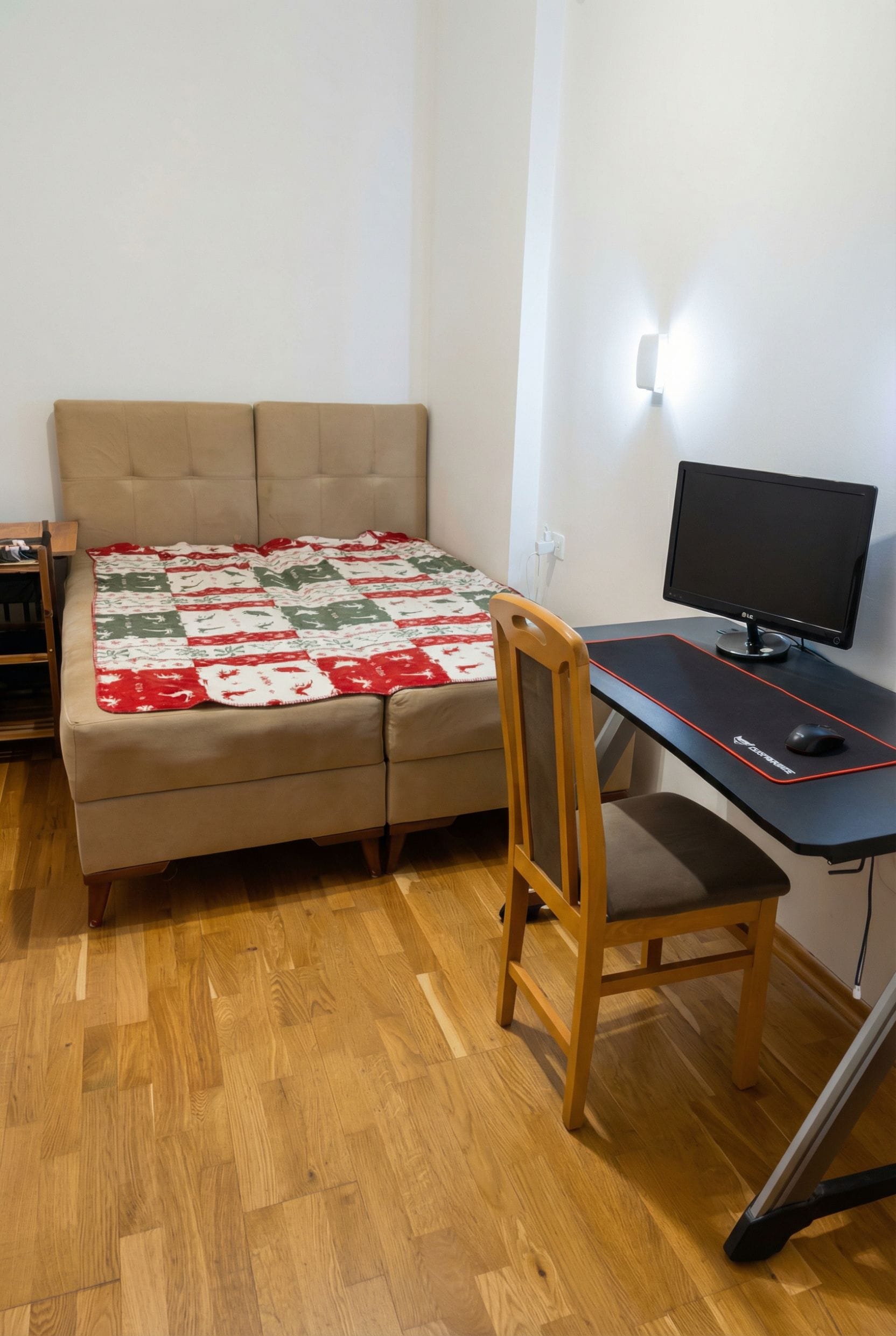 Spavaća soba u stanu u Budvi, Crna Gora: bračni krevet, radni sto sa monitorom i parketni pod.