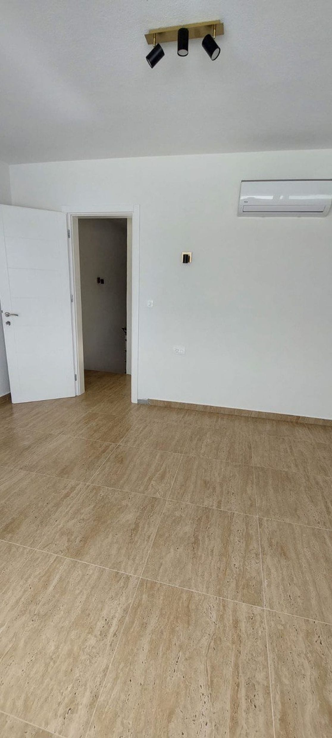 Svetla dnevna soba u taunhausu, Luštica, Crna Gora: pločice na podu, klima-uređaj i moderno osvetljenje.