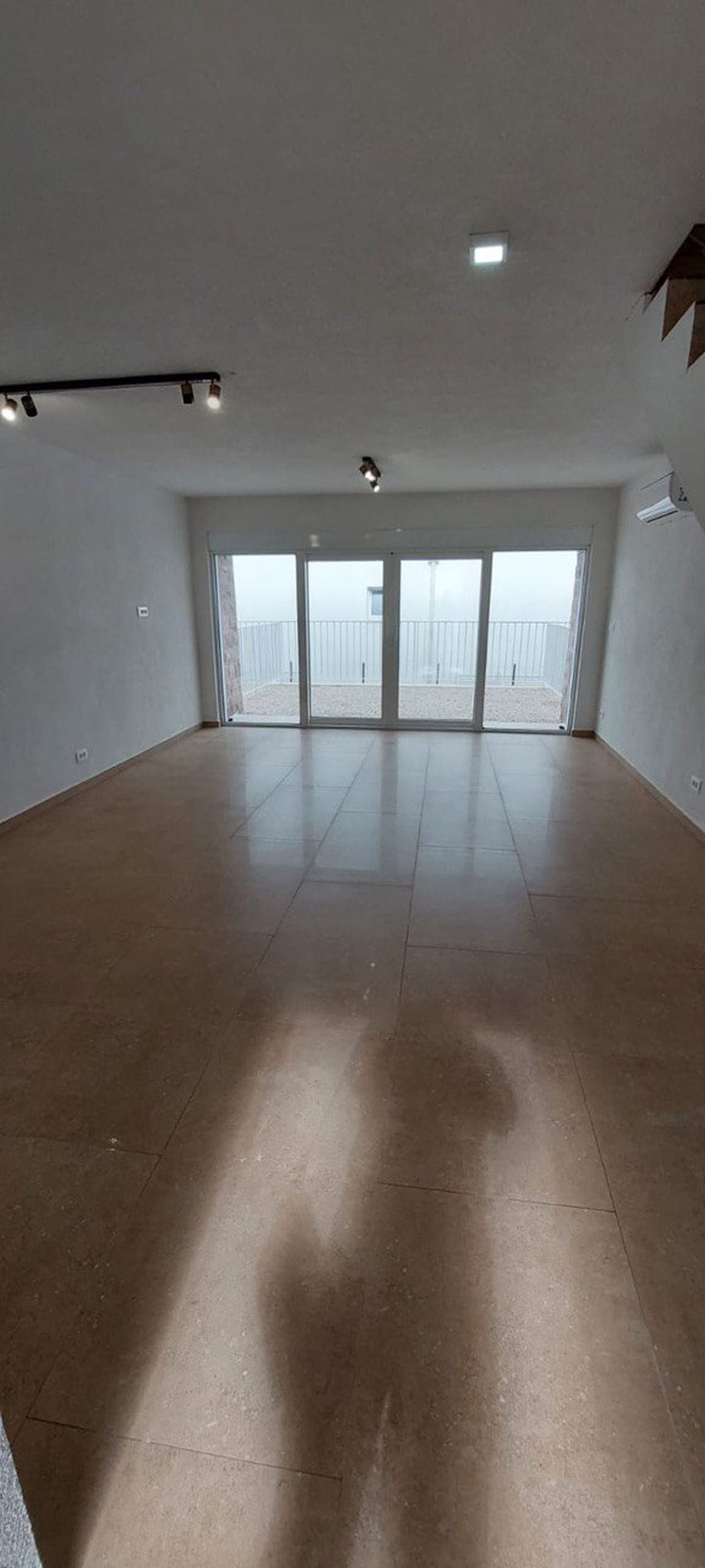 Prostrana dnevna soba u taunhausu, Luštica, Crna Gora: svetla obrada, pločice na podu i izlaz na terasu.