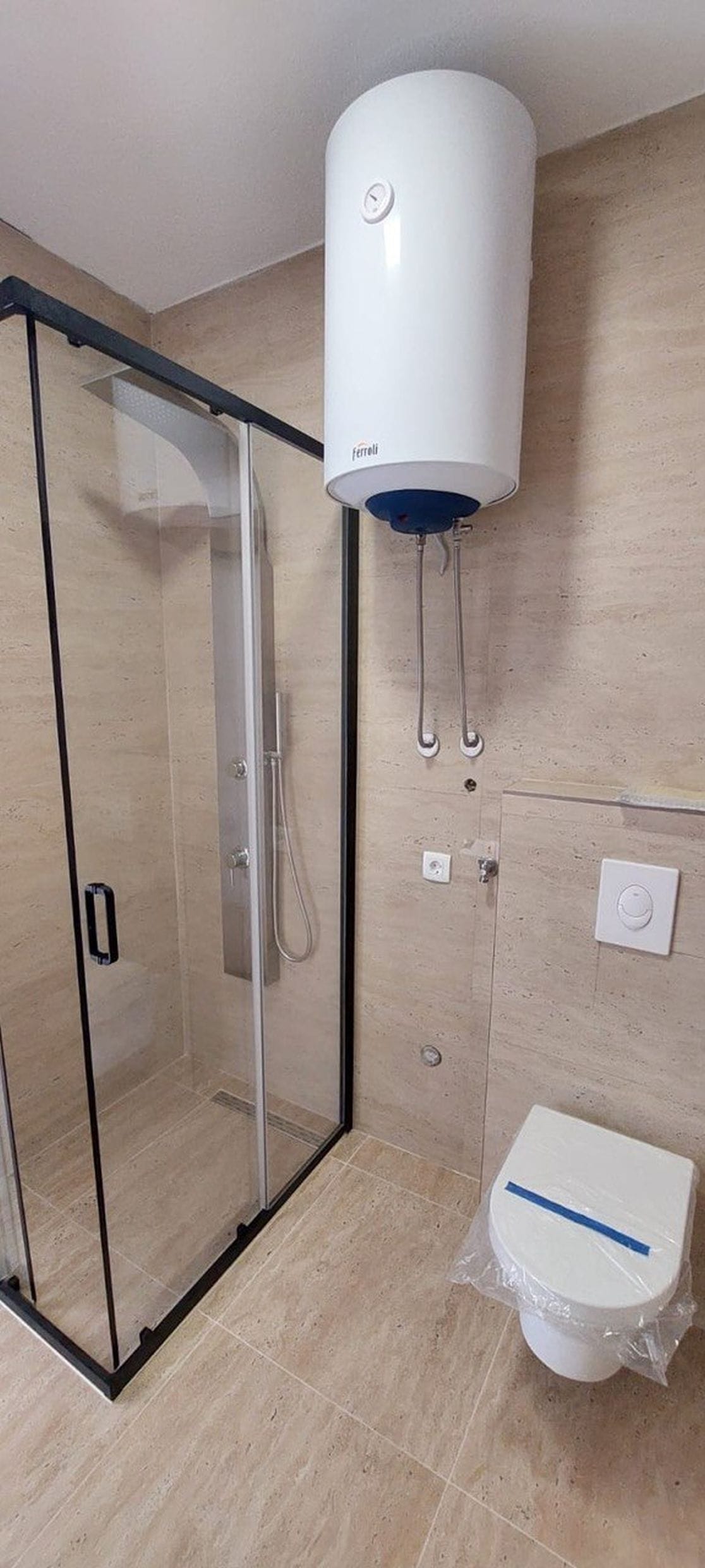 Savremeno kupatilo u townhouseu, Luštica, Crna Gora: tuš kabina, viseća WC šolja i Ferroli bojler.