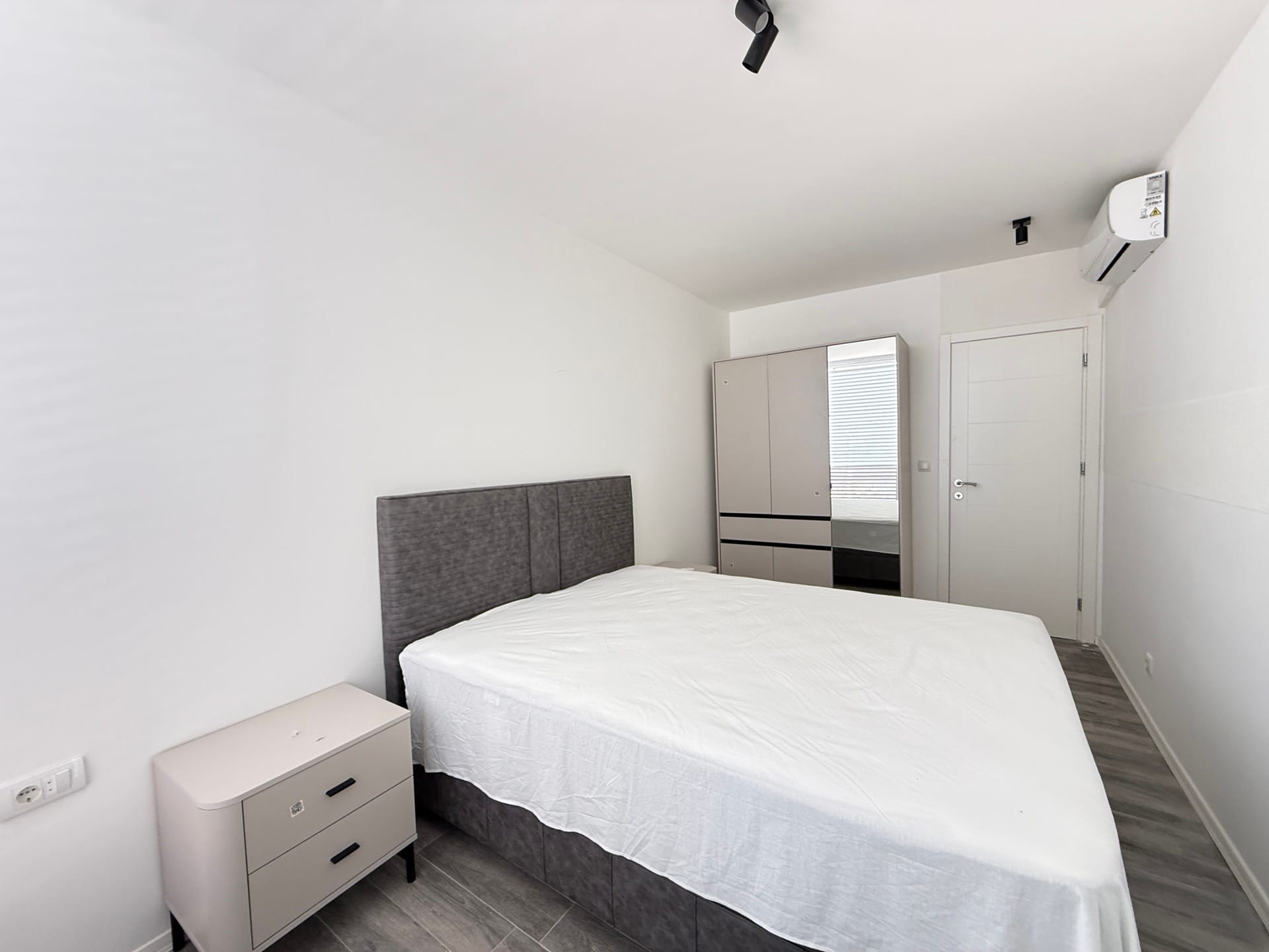 Savremena spavaća soba u townhouseu, Đuraševići, Luštica, Crna Gora: bračni krevet, ormar i svetao enterijer.