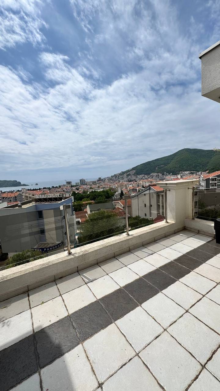 Prostrana terasa s panoramskim pogledom na more i planine u Budvi, Crna Gora. Keramička podna obloga, staklena ograda.