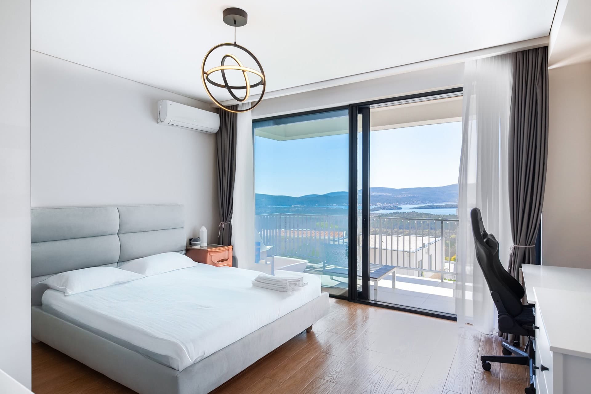 Спальня с двуспальной кроватью и панорамным видом на море в вилле Кавач, Черногория. Современный интерьер с балконом.