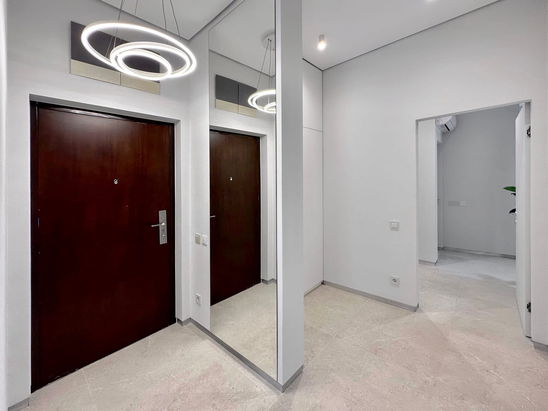 Hall d’entrée moderne avec miroir et éclairage design dans un appartement, Becici, Monténégro.