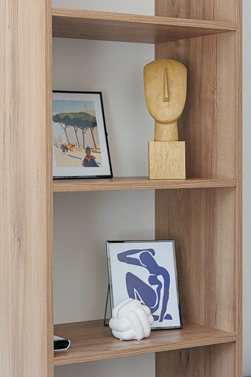 Étagère en bois avec décoration dans l’intérieur d’un appartement à Bečići, Monténégro : statuette, tableaux et accessoires élégants.