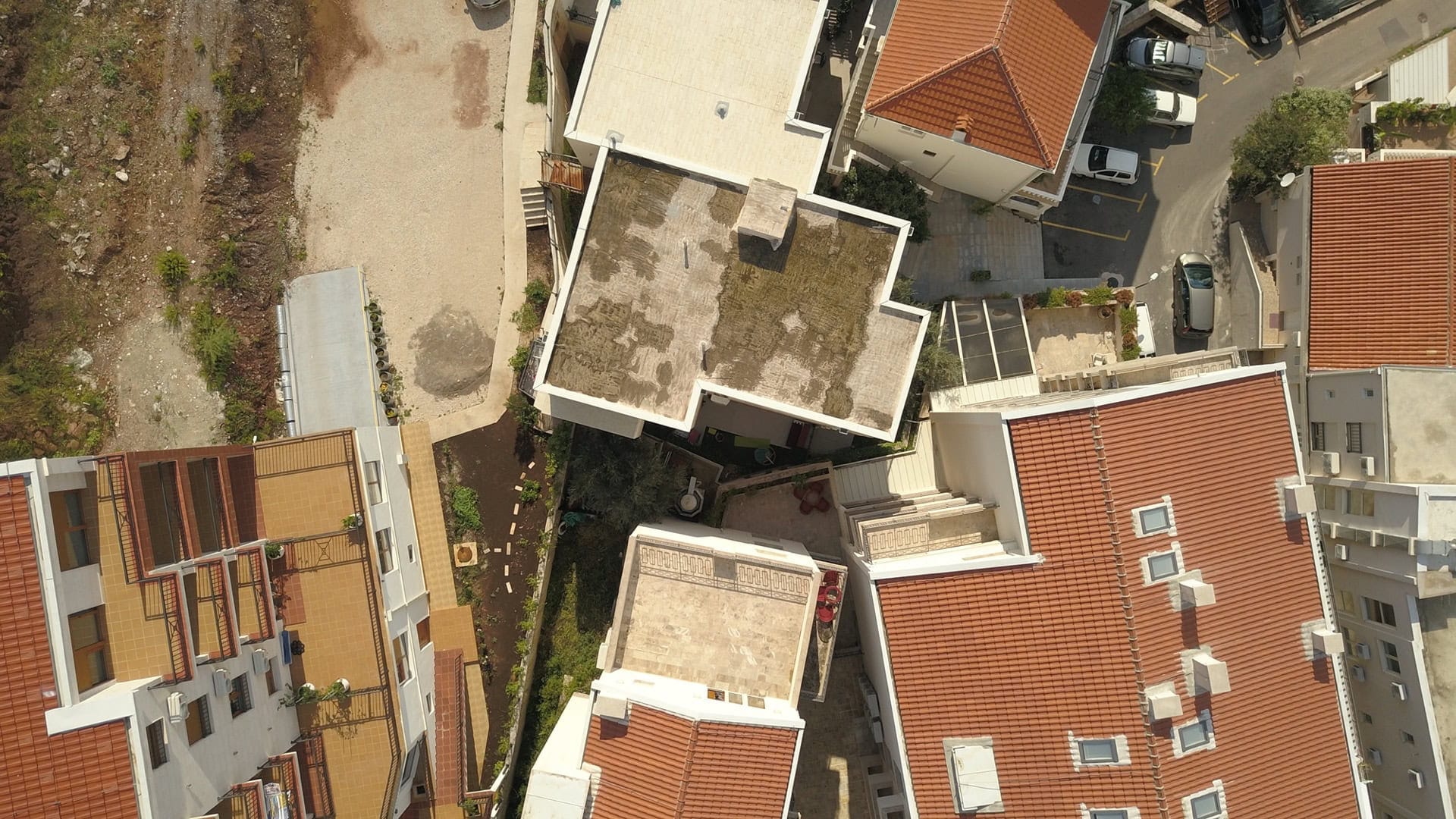 Aerial view of a residential complex with tiled roofs in Pržno, Montenegro: building architecture and surrounding grounds.