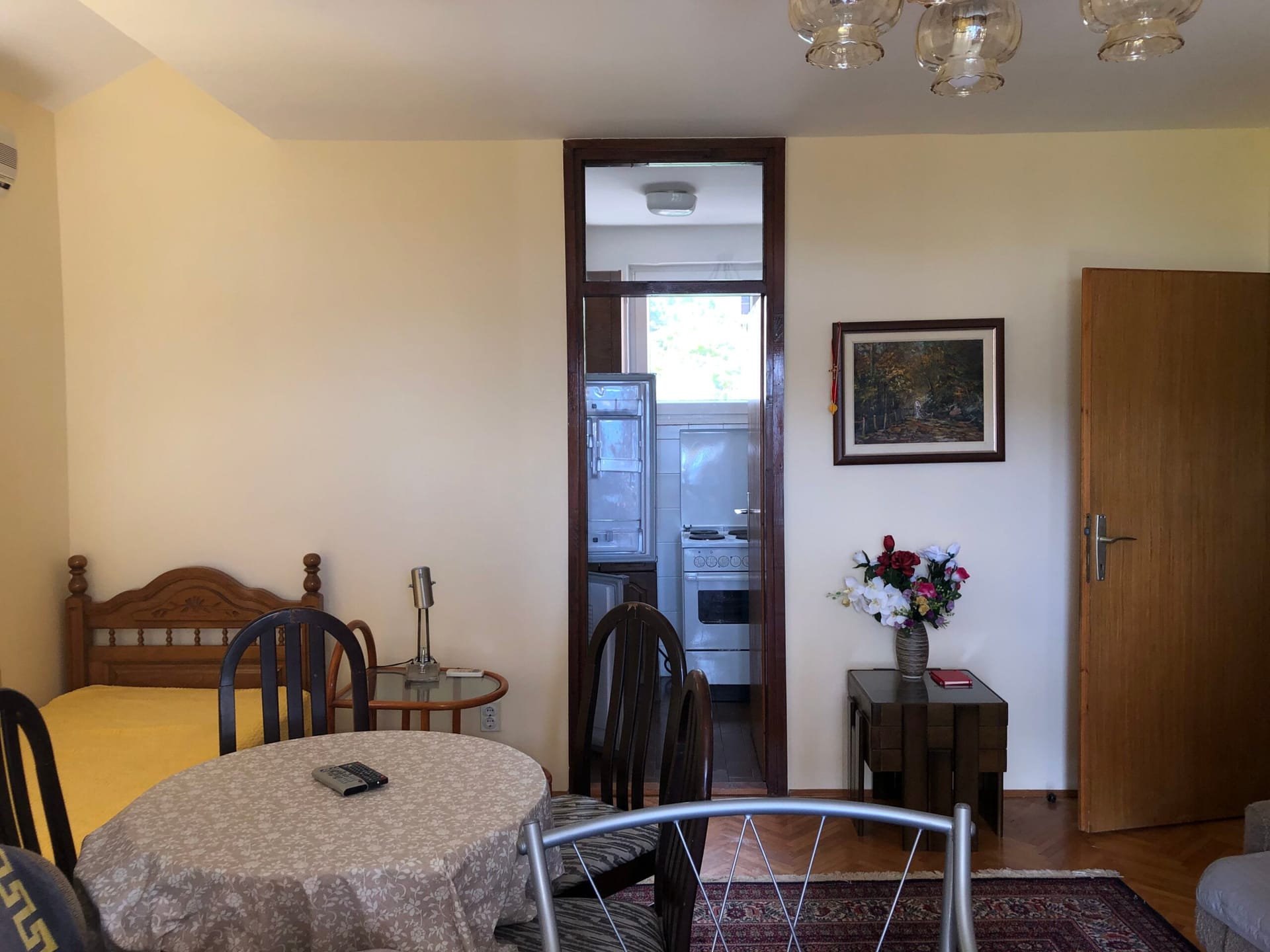 Living room with dining area and passage to the kitchen in an apartment, Baosici, Montenegro. Wooden furniture and parquet flooring.