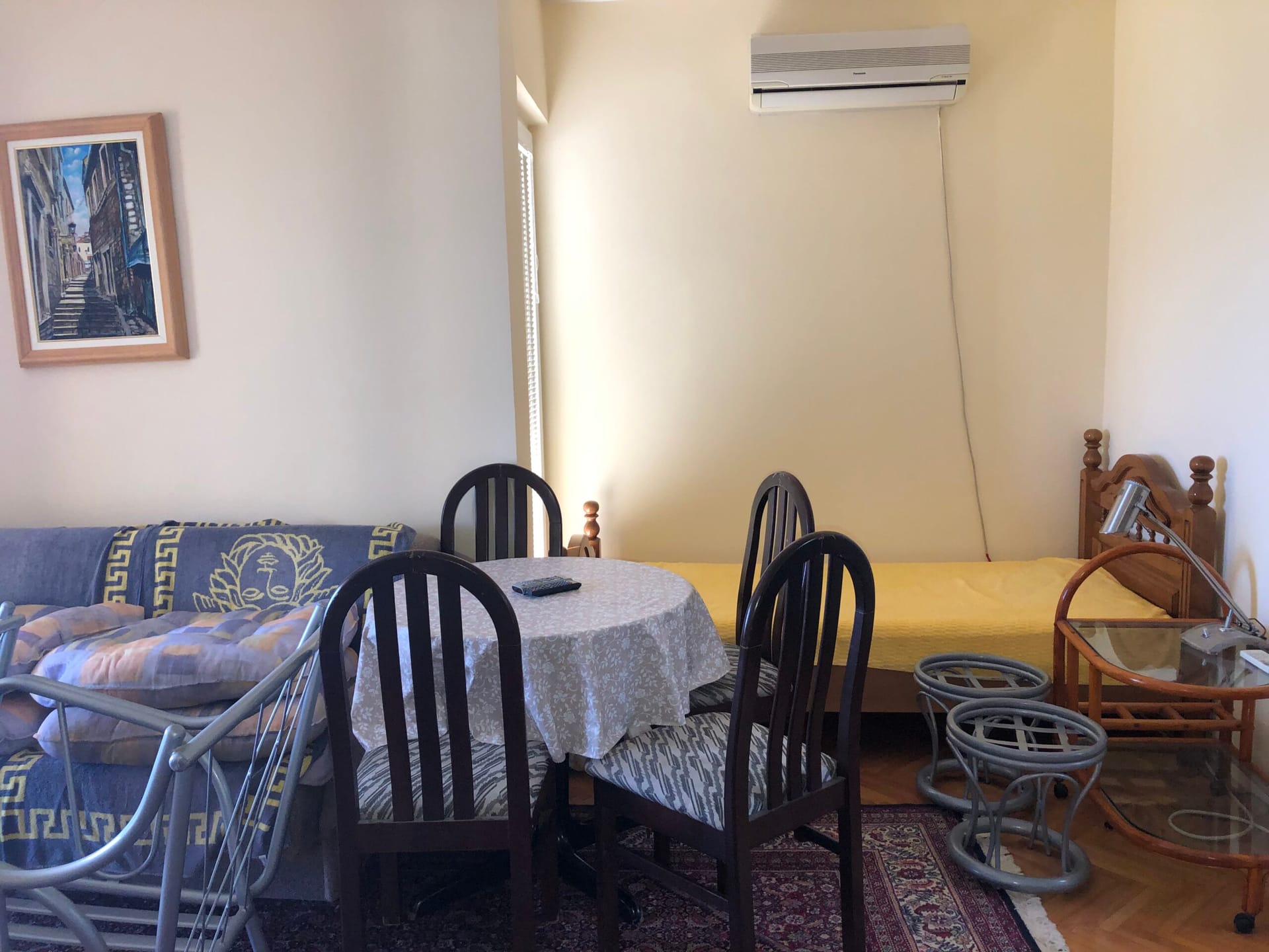 Living room in an apartment in Baošići, Montenegro: dining area with a table, chairs, a sofa, and air conditioning.