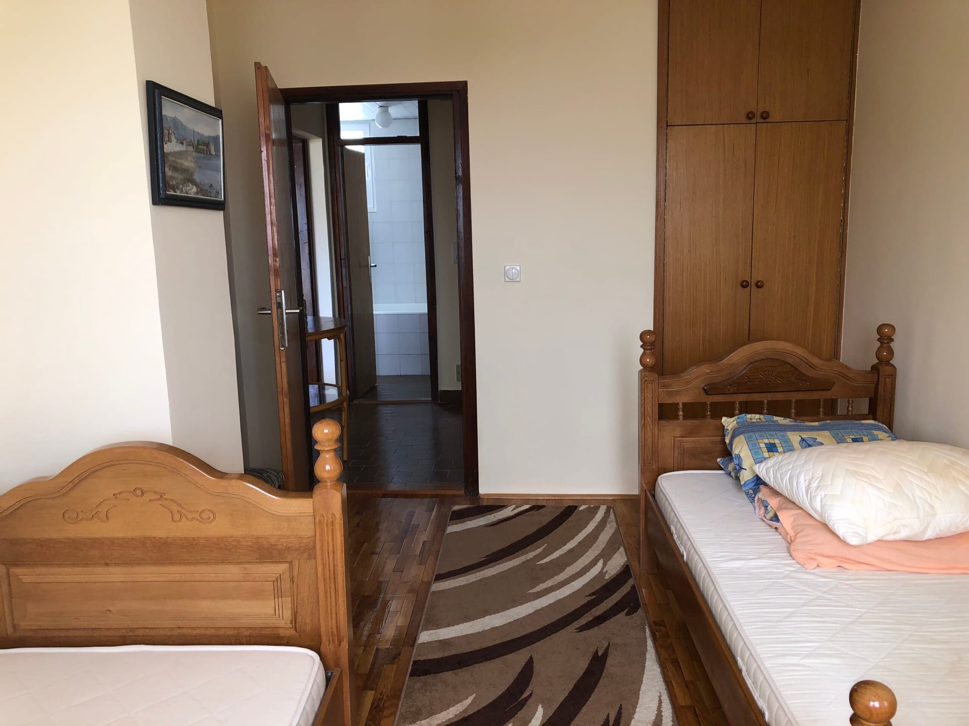 Bedroom with two wooden beds and a built-in wardrobe in an apartment, Baosici, Montenegro.