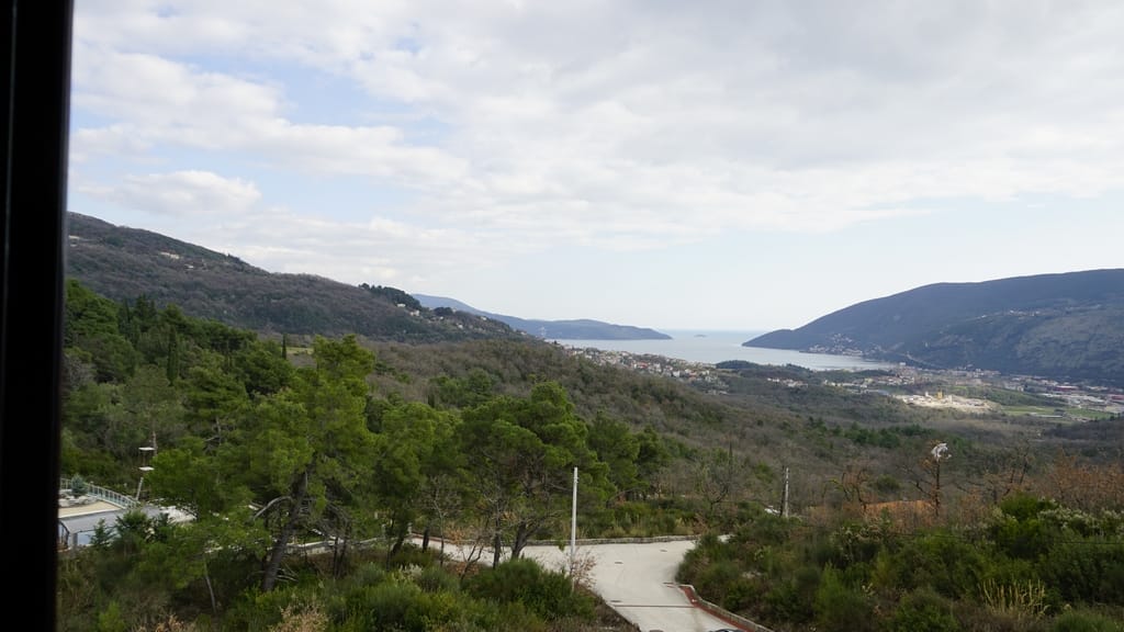 Vue panoramique sur la mer et les montagnes depuis une villa à Igalo, Herceg Novi, Monténégro : collines verdoyantes et baie maritime.