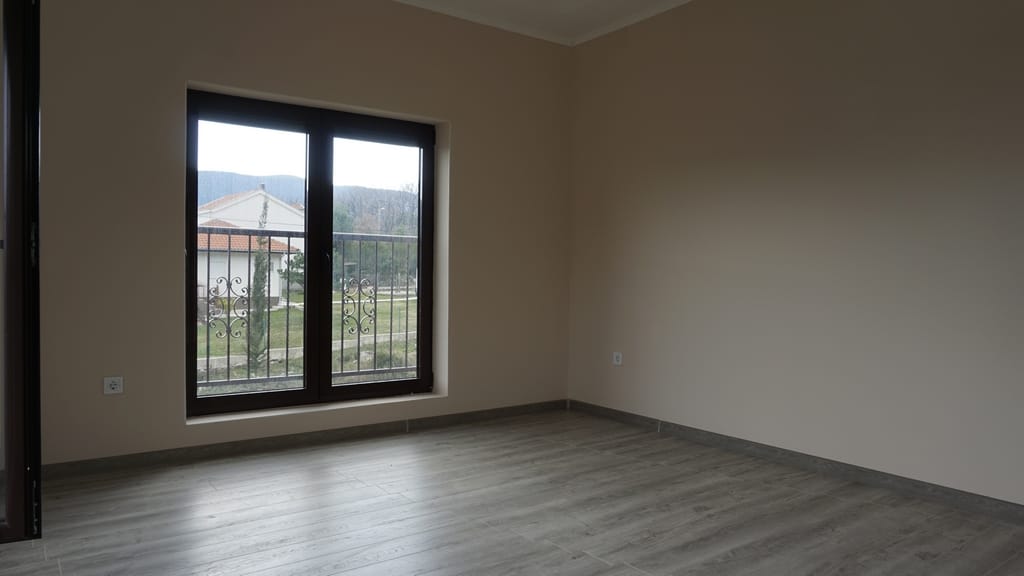 Salon lumineux avec parquet stratifié et baie vitrée panoramique dans une villa à Igalo, Herceg Novi, Monténégro.