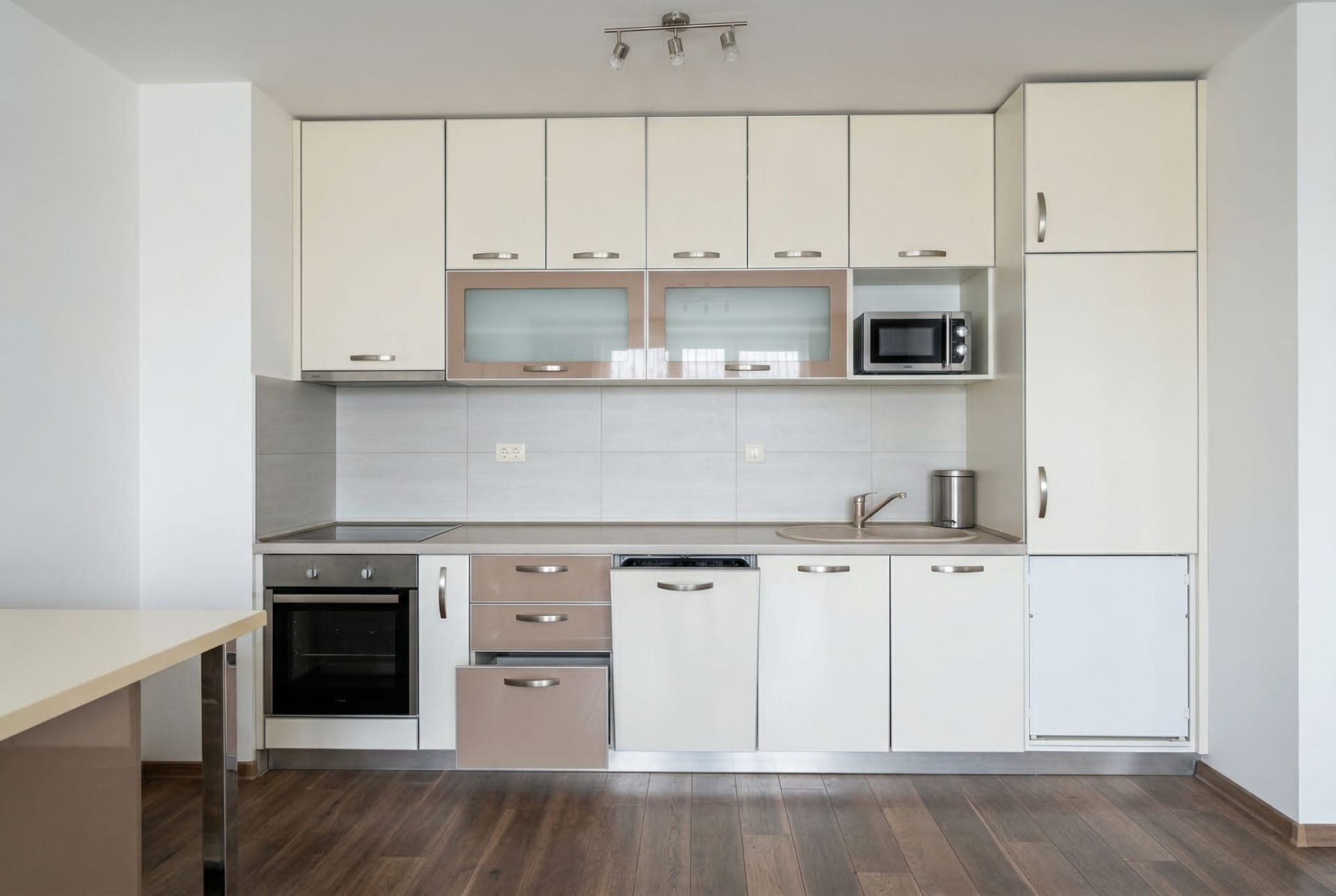 Modern bright kitchen in an apartment in Pržno, Montenegro: built-in appliances, white fronts, and dark flooring.