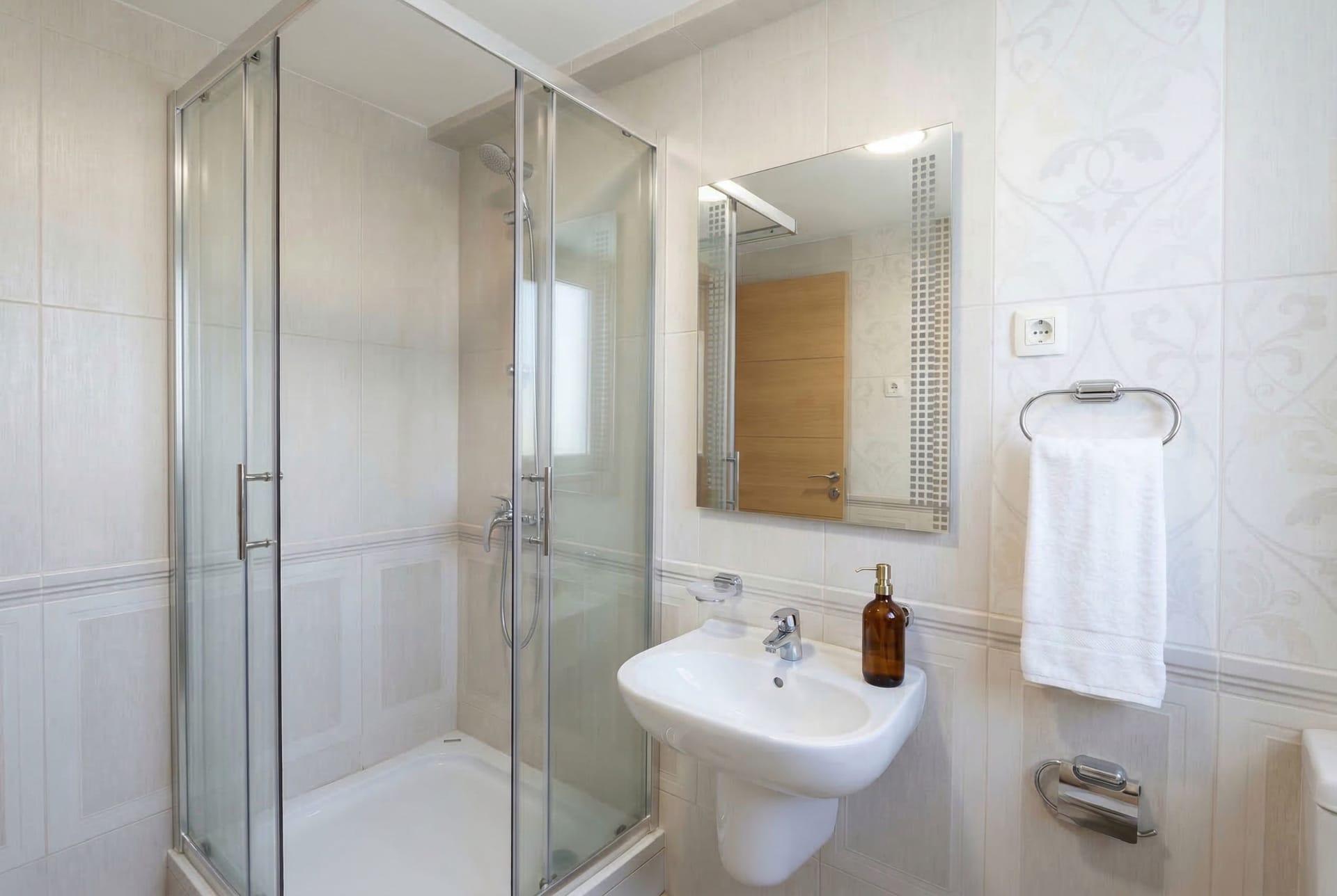 Bright bathroom with a shower cabin in an apartment, Pržno, Montenegro: modern fixtures and tile.