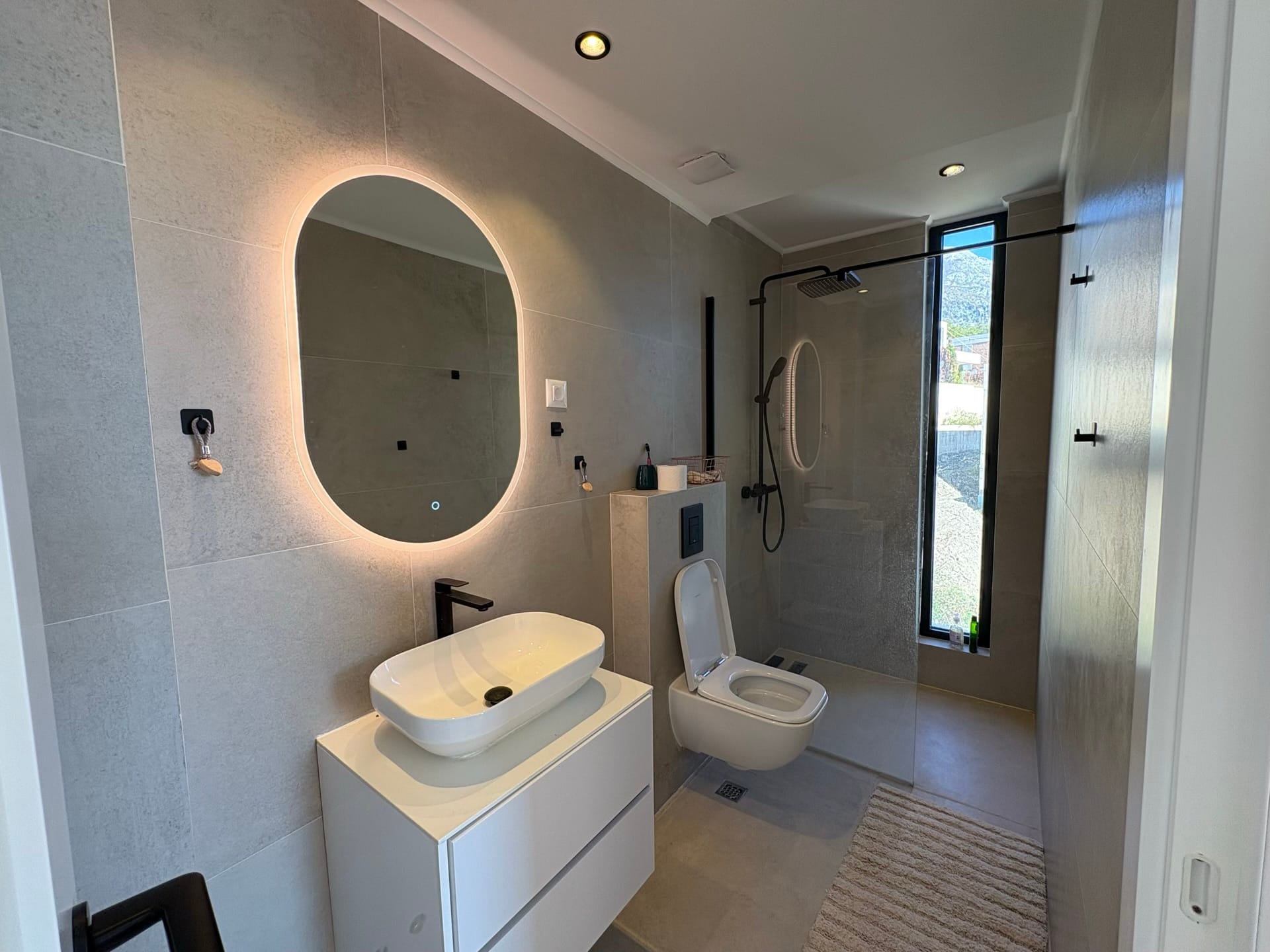 Modern bathroom with a shower cabin and mirror lighting in a residential complex, Herceg Novi, Montenegro.