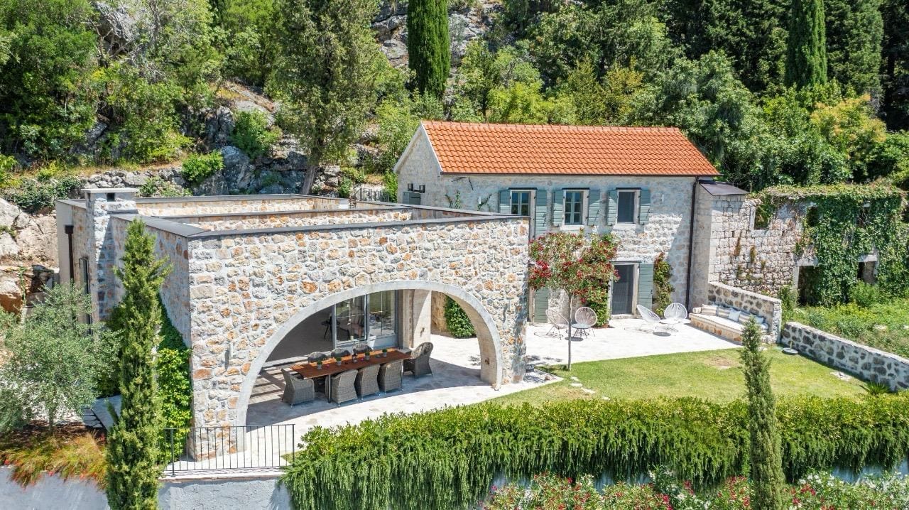 Villa en pierre à Herceg Novi, Monténégro : terrasse avec coin repas, aménagement paysager et vue sur les montagnes.