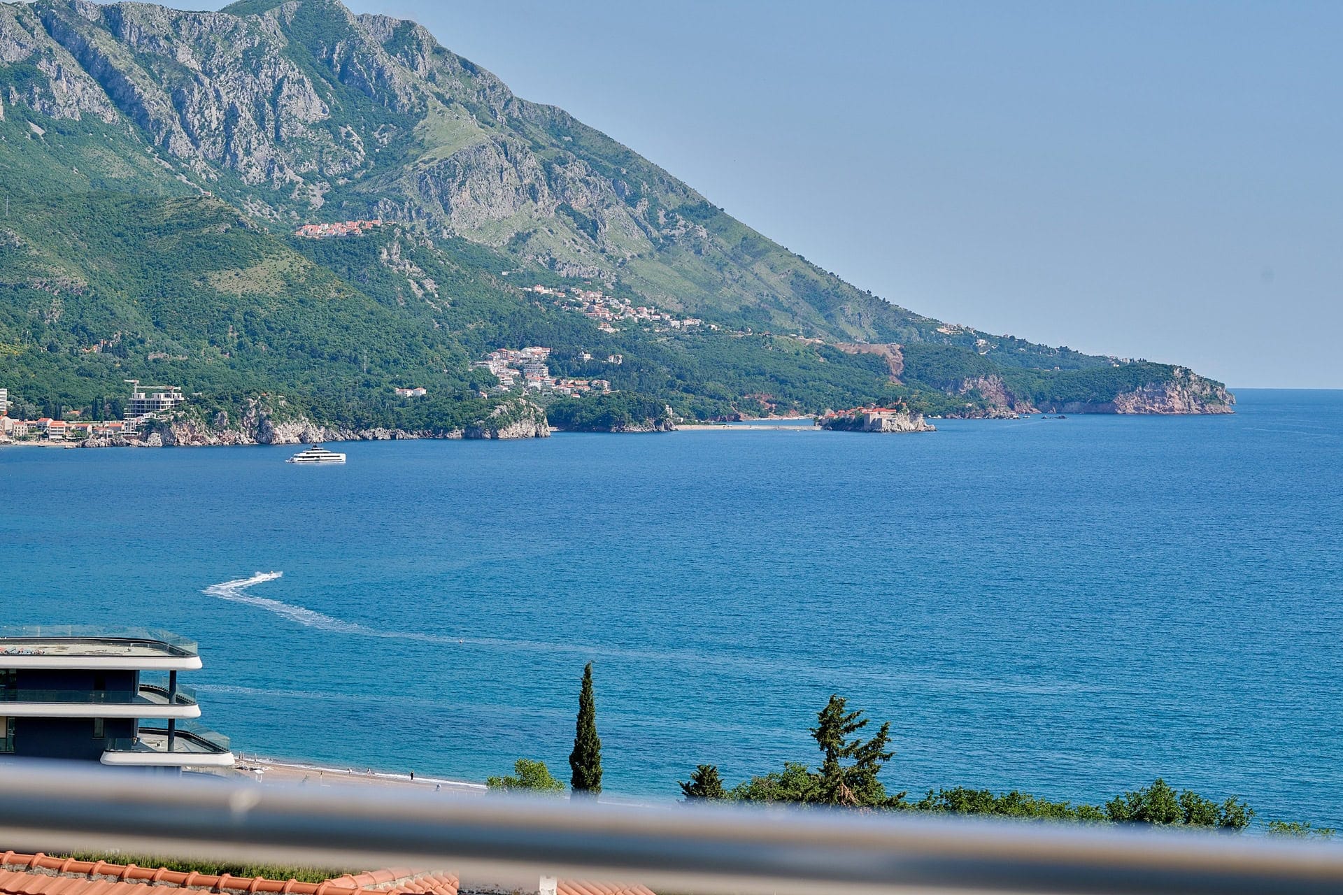 Panoramski pogled na Jadransko more i planine sa balkona stana u Bečićima, Crna Gora. Pogled na plažu i ostrvo Sveti Stefan.
