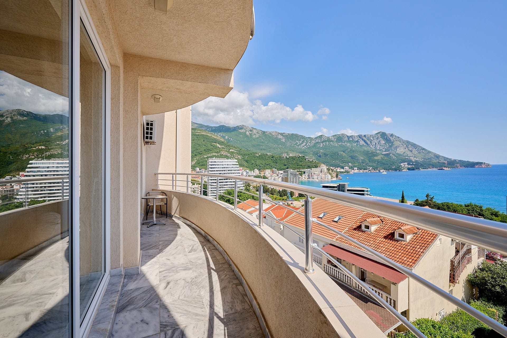 Prostran balkon sa mermernim podom i panoramskim pogledom na more i planine u stanu, Bečići, Crna Gora.