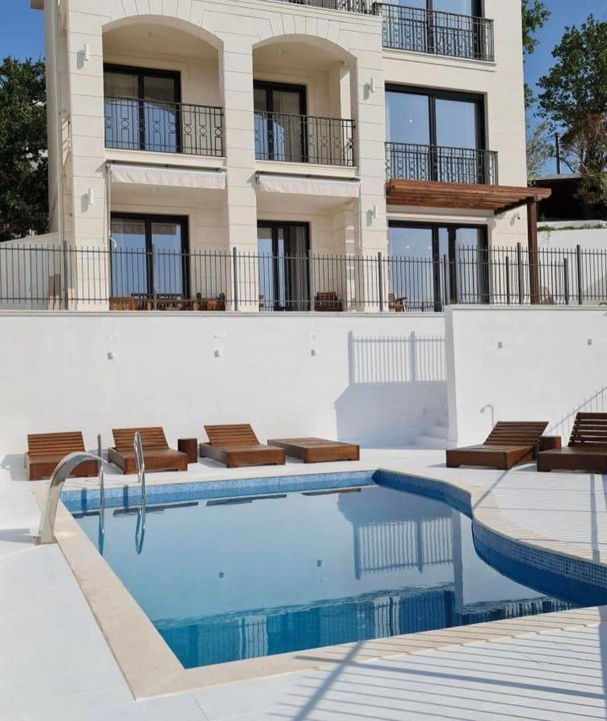 Modern villa with a pool and sun loungers in Skočidjevojka, Budva, Montenegro: view of the facade and relaxation area.