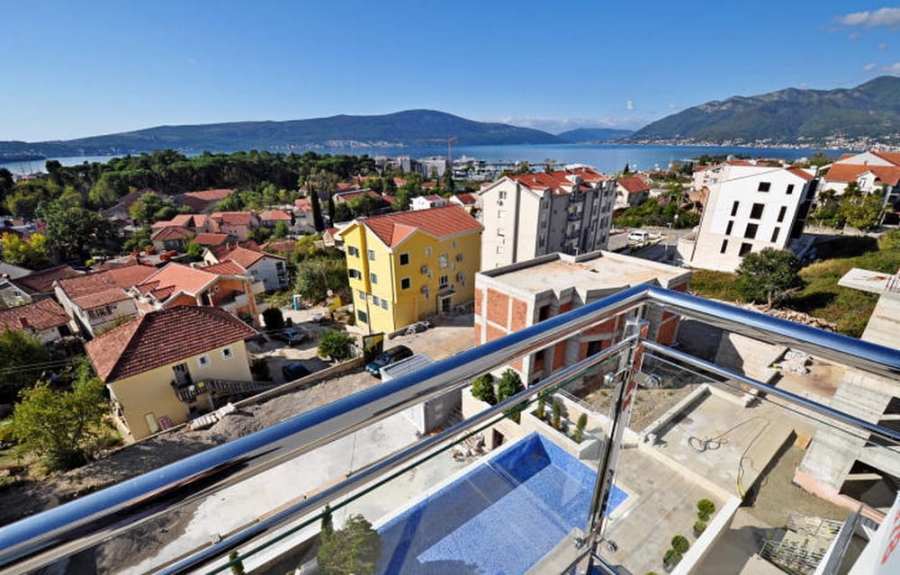 Widok z balkonu na basen i panoramę miasta Tivat, Czarnogóra: nowoczesny kompleks mieszkalny z widokiem na morze.