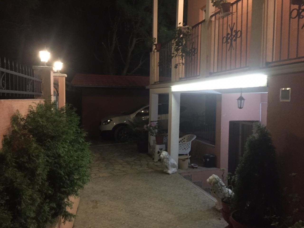 Two-story house in Shushan, Montenegro: night view of the private grounds, parking area, and lit terrace.