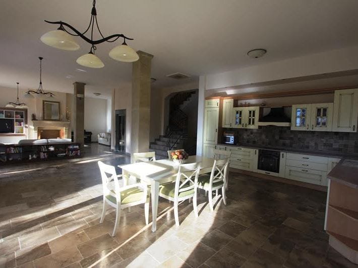 Spacious kitchen-dining room with stone flooring and a classic kitchen set in a villa in Petrovac, Montenegro.