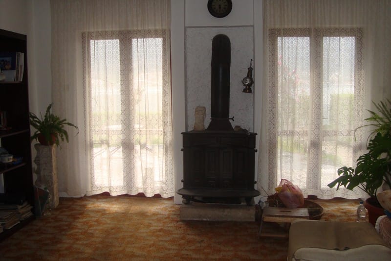 Salon avec cheminée et baies vitrées dans une maison à vendre, ville de Dobrota, Monténégro.