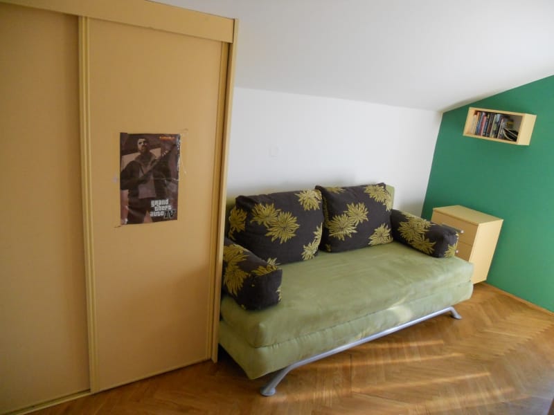 Dnevna soba u stanu u Budvi, Crna Gora: sofa s cvetnim dezenom, klizni ormar, parket i zelena akcentna zid.
