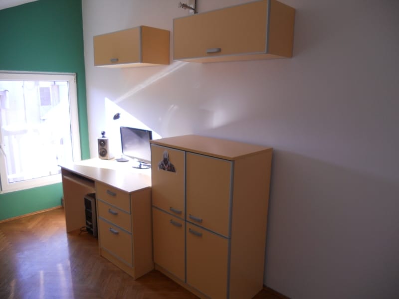 Radna zona u spavaćoj sobi stana u Budvi, Crna Gora: radni sto, ormari, računar i parket.
