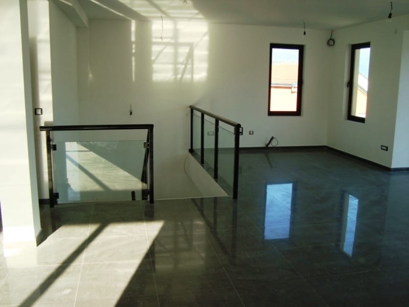 Geräumiges Wohnzimmer in Baošići, Montenegro: helle Ausstattung, glänzendes Feinsteinzeug und eine Treppe mit Glasgeländer.