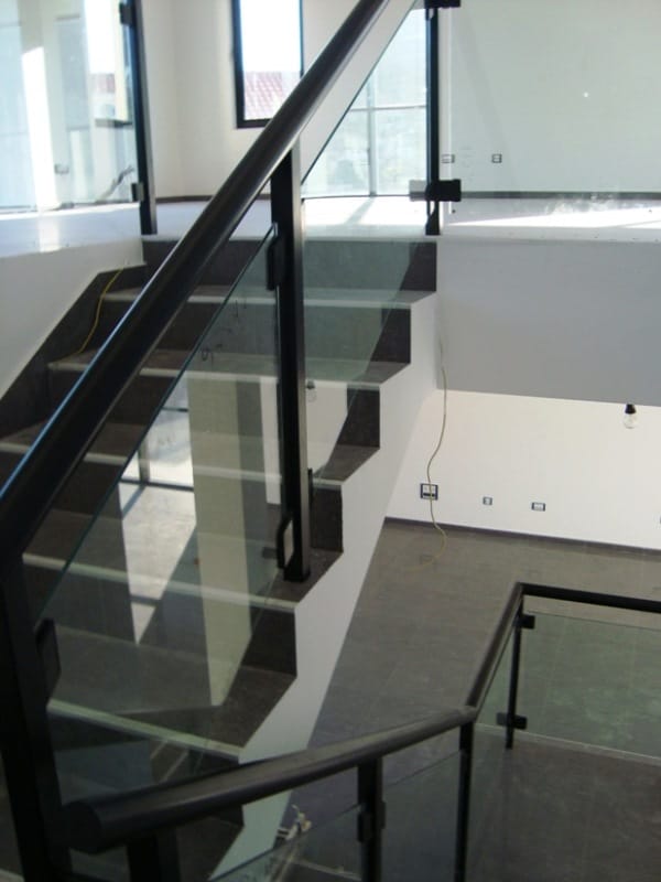 Moderne Treppe mit schwarzen Geländern und Glasgeländer in einem Gewerberaum, Baošići, Montenegro.