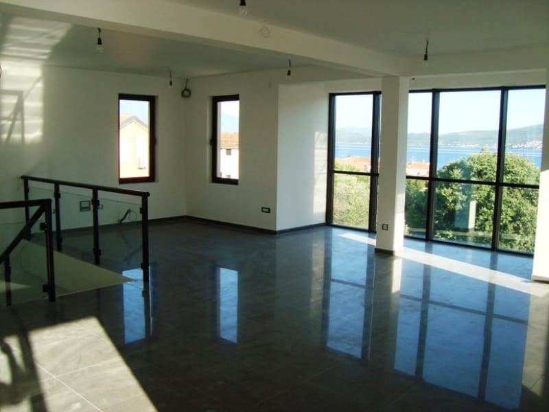 Geräumiges Wohnzimmer mit Panoramafenstern und Meerblick in Baošići, Montenegro: helle Ausstattung und Fliesenboden.